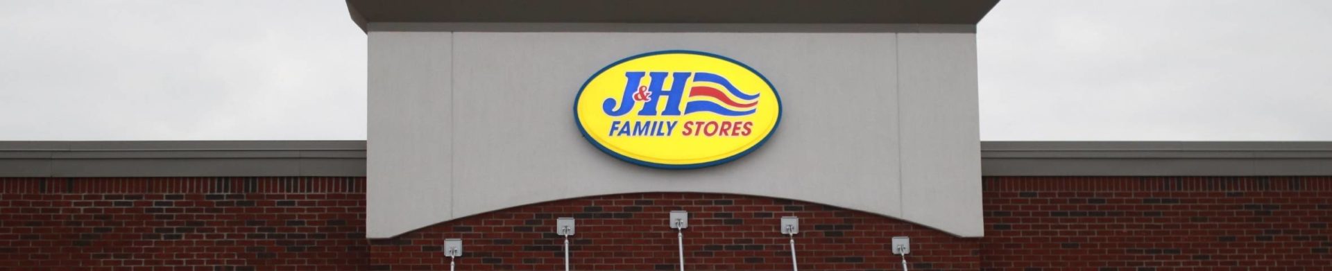 J&H Family Stores exterior white concrete above brick