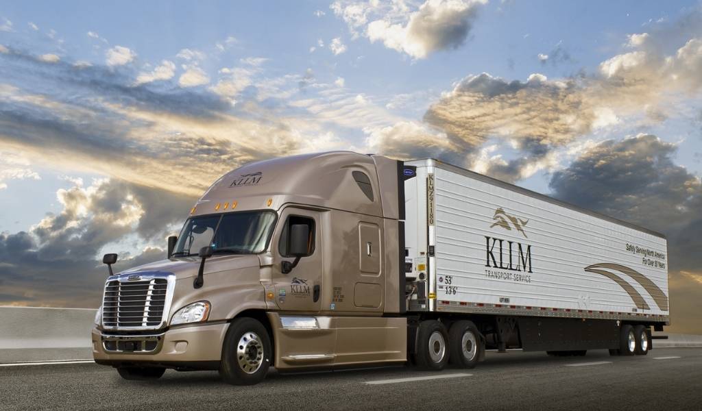 a beige KLLM transport truck with white box