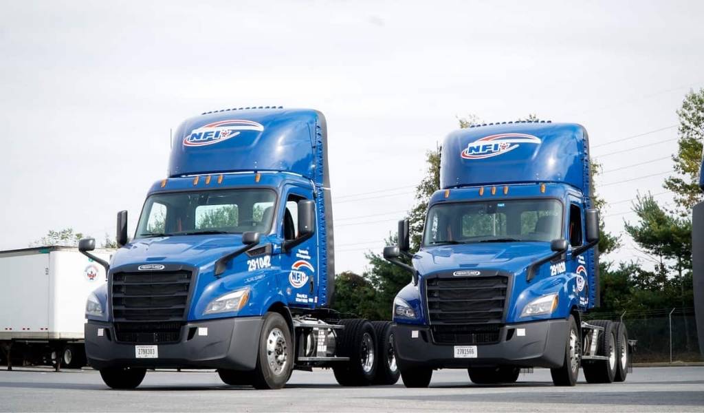 two blue NFI Industries transport trucks