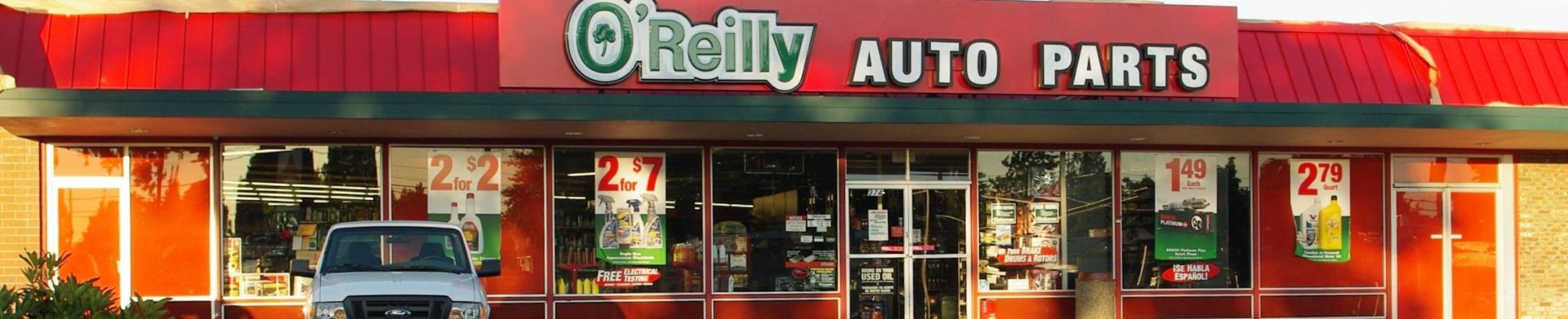 exterior of O'Reilly Auto Parts store showing red building front and green and white company name above windows